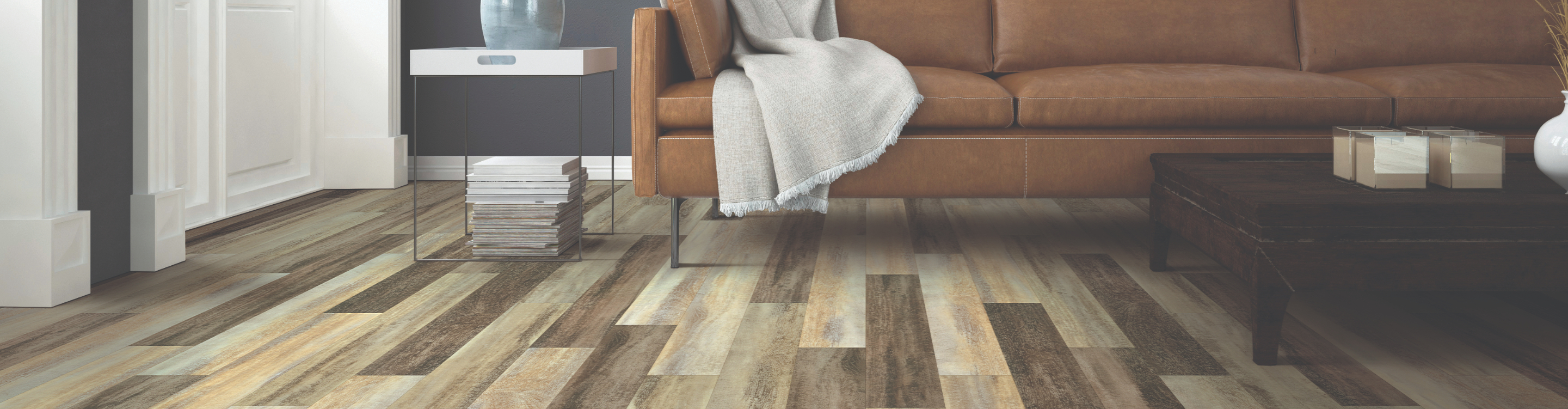 wood flooring multi colored plank in living area with tan leather sofa